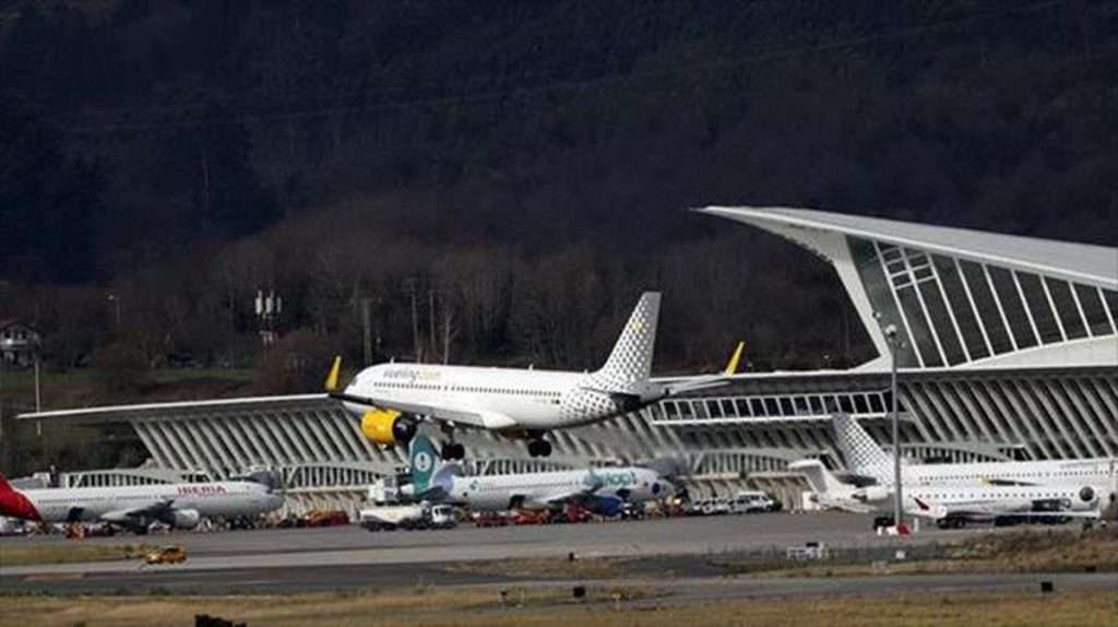 VTC Elvis en el aeropuerto de Bilbao, varios aviones estacionados en una moderna terminal del aeropuerto, con una arquitectura distintiva, enclavada en colinas boscosas cerca de los traslados de Santander y Bilbao. servicios de VTC en Cantabria